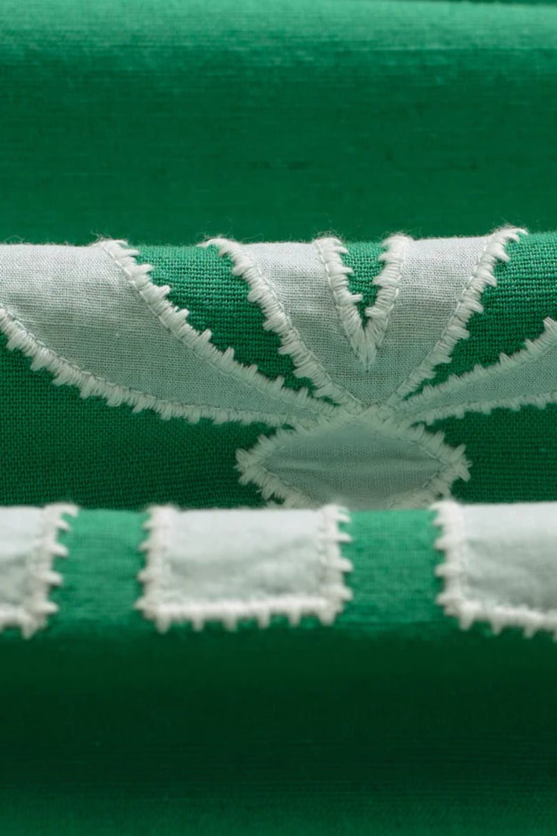 Close-up of green and white striped fabric with embroidered pattern