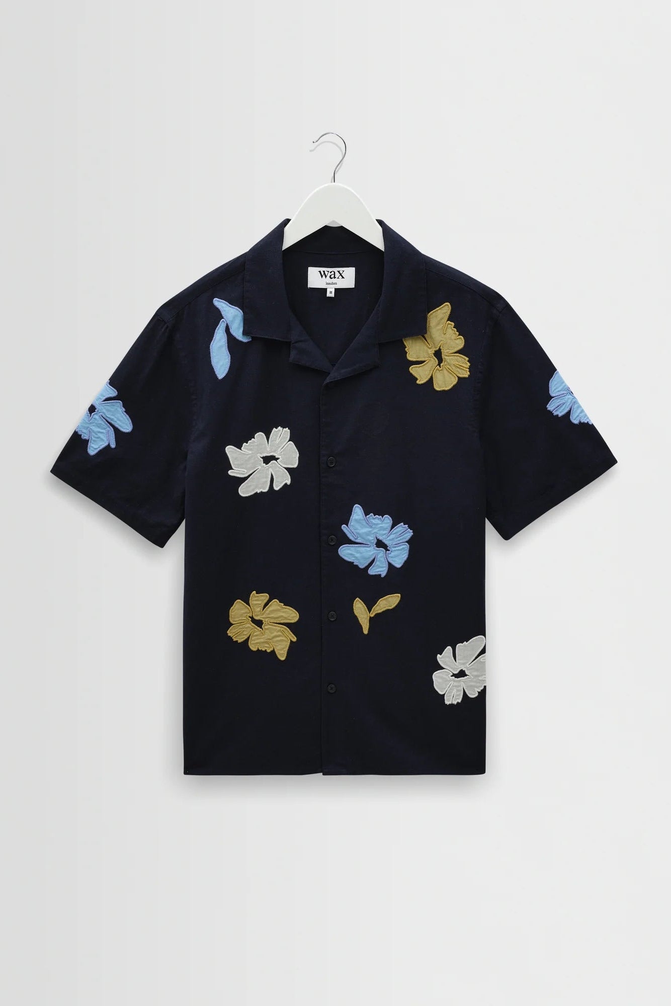 Black shirt with colorful floral patterns on a white background