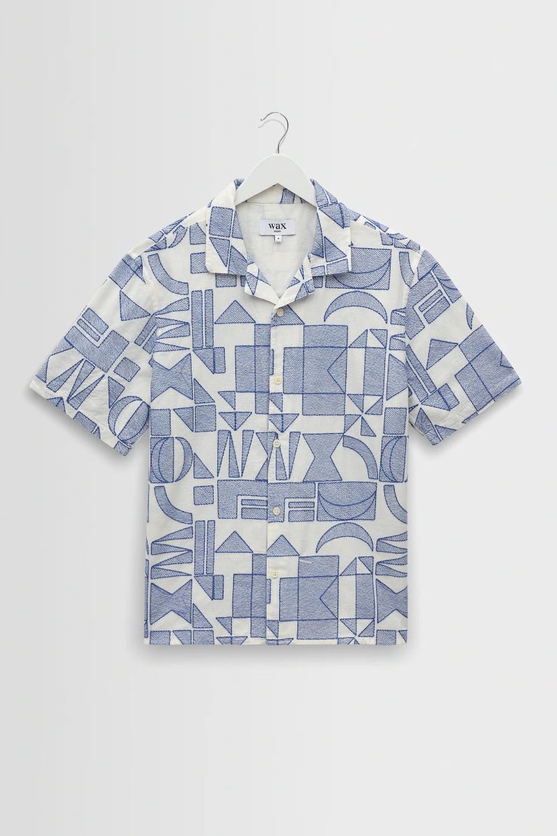 Short-sleeve shirt with geometric pattern on a hanger against a white background