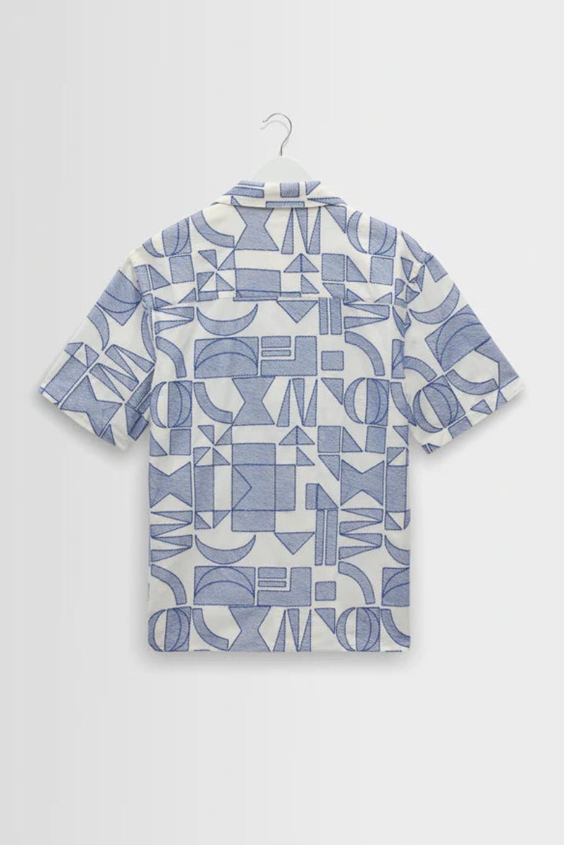 Short-sleeve shirt with geometric pattern on a hanger against a light gray background