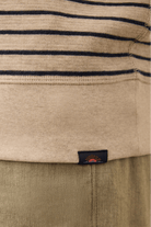Close-up of a beige and navy striped garment with a brand label.
