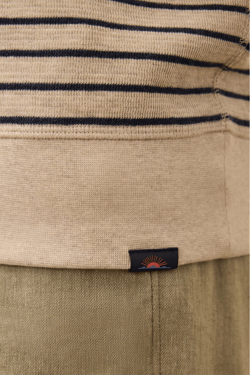 Close-up of a beige and navy striped garment with a brand label.