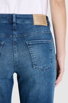 Blue jeans with a brown patch on a white background