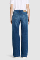 Person wearing blue jeans on a white background