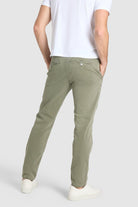 Person wearing olive green pants and a white shirt on a light gray background