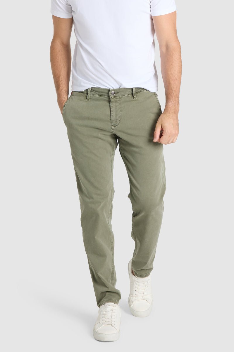 Person wearing olive green pants and a white shirt on a light gray background