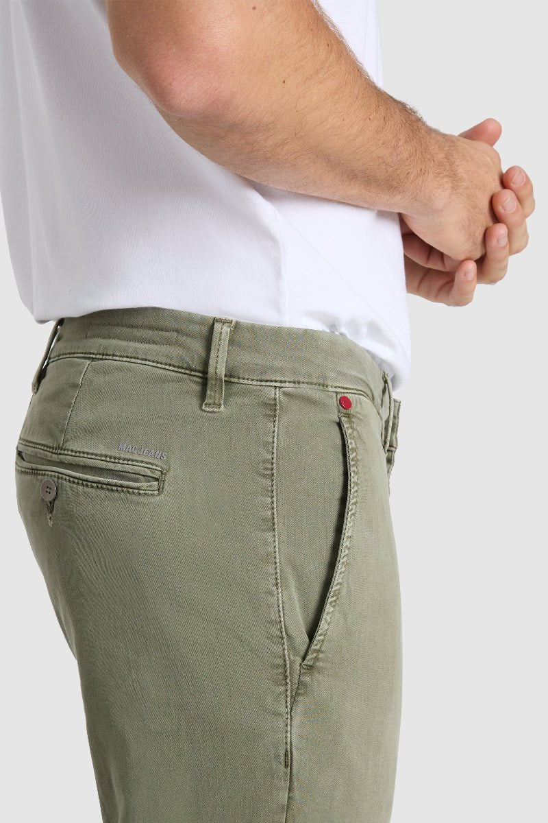 Person wearing olive green pants and a white shirt on a light gray background