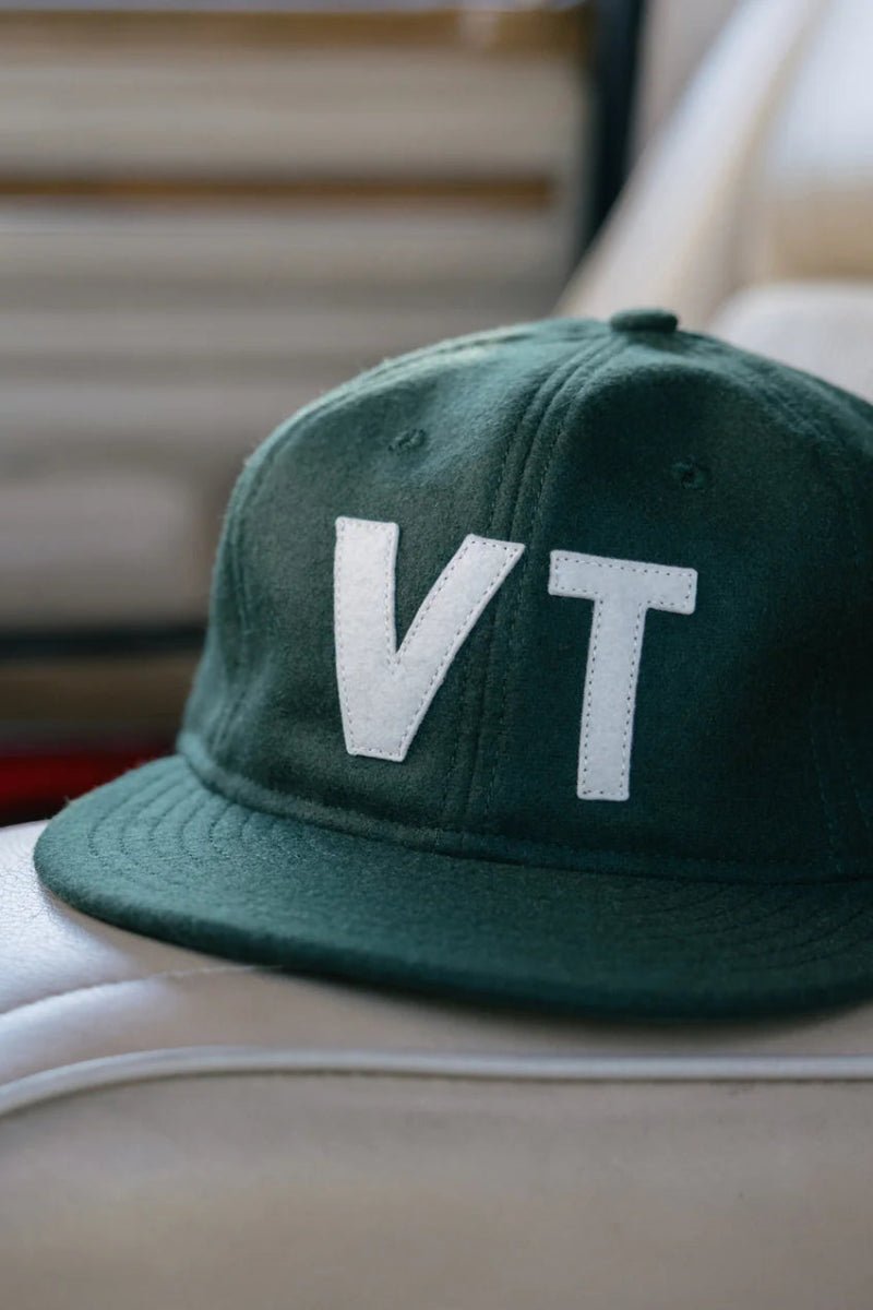 Green cap with 'VT' on a car seat