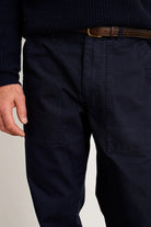 Navy pants worn by a person on a plain background