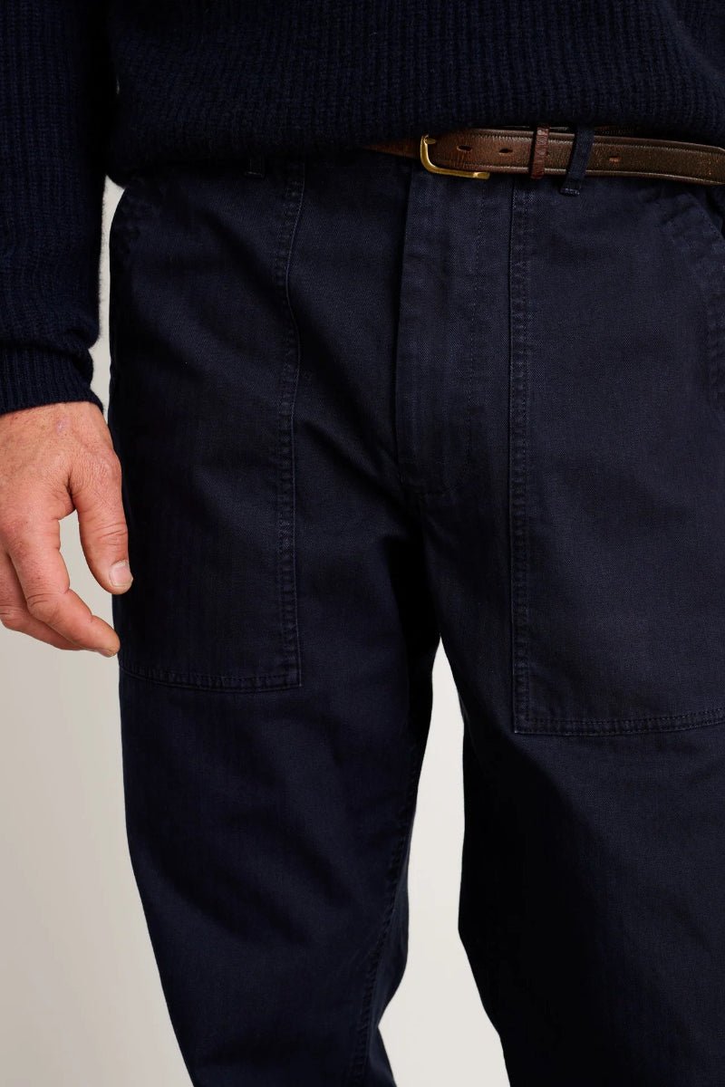 Navy pants worn by a person on a plain background