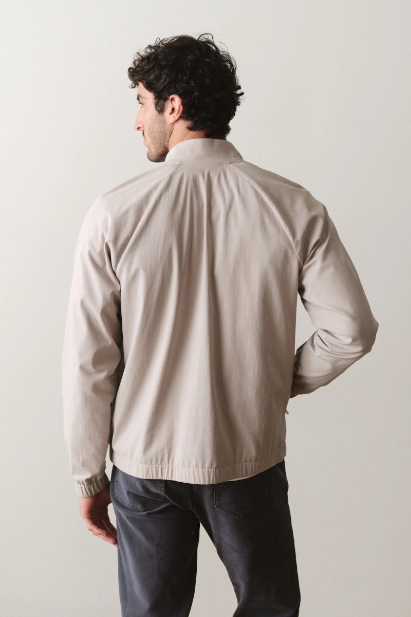 Man wearing a beige jacket against a plain background