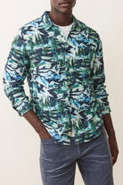 Person wearing a patterned shirt with a neutral background