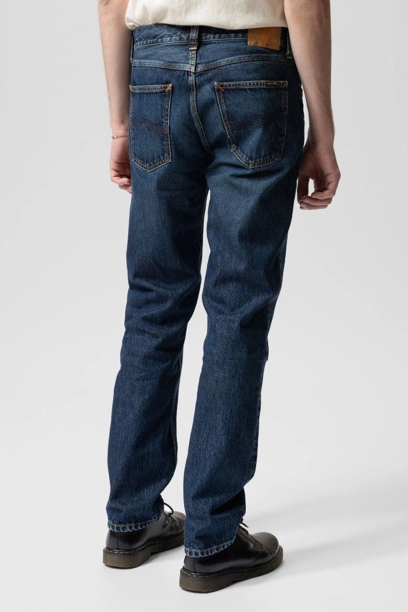 Person wearing blue jeans on a white background