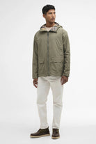 Man wearing a green jacket with a plaid hood on a white background