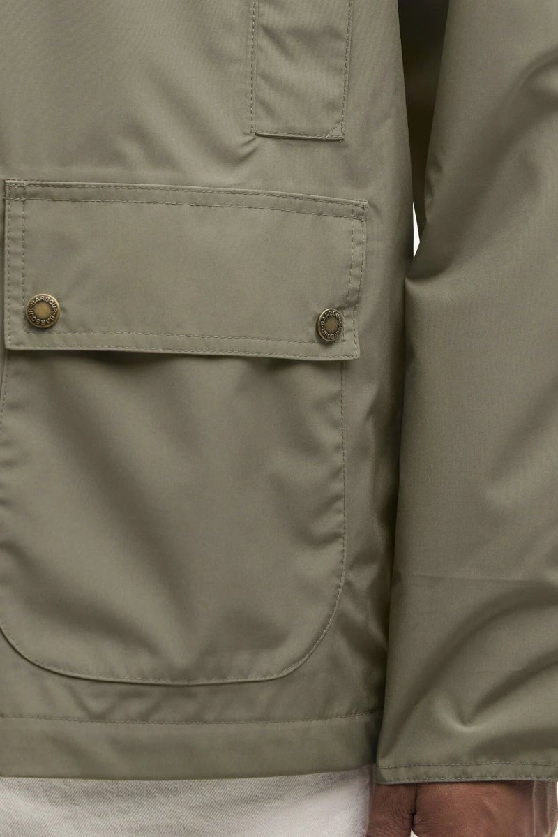 Close-up of a green jacket with pockets and buttons on a white background