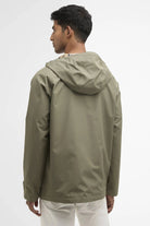 Man wearing a green raincoat on a white background