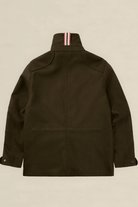 The back view of an olive green utility jacket with a high collar featuring a signature red, white, and blue striped ribbons detail, displayed on a neutral beige background.