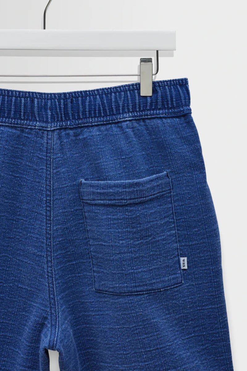 Blue denim shorts on a hanger against a white background