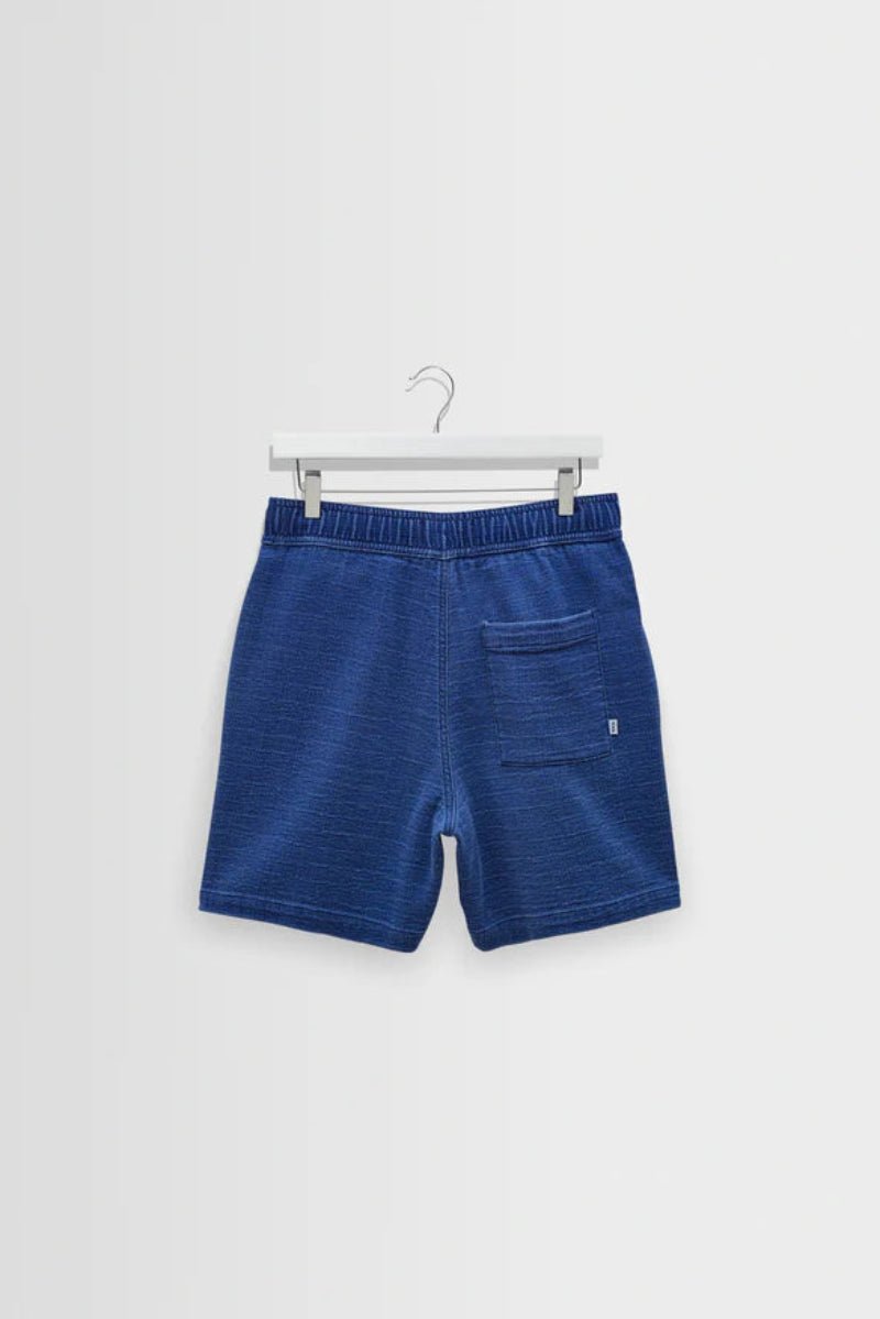 Blue shorts on a hanger against a white background
