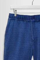Blue denim shorts on a hanger against a white background