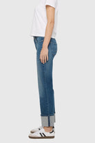 Person wearing blue jeans with a white background