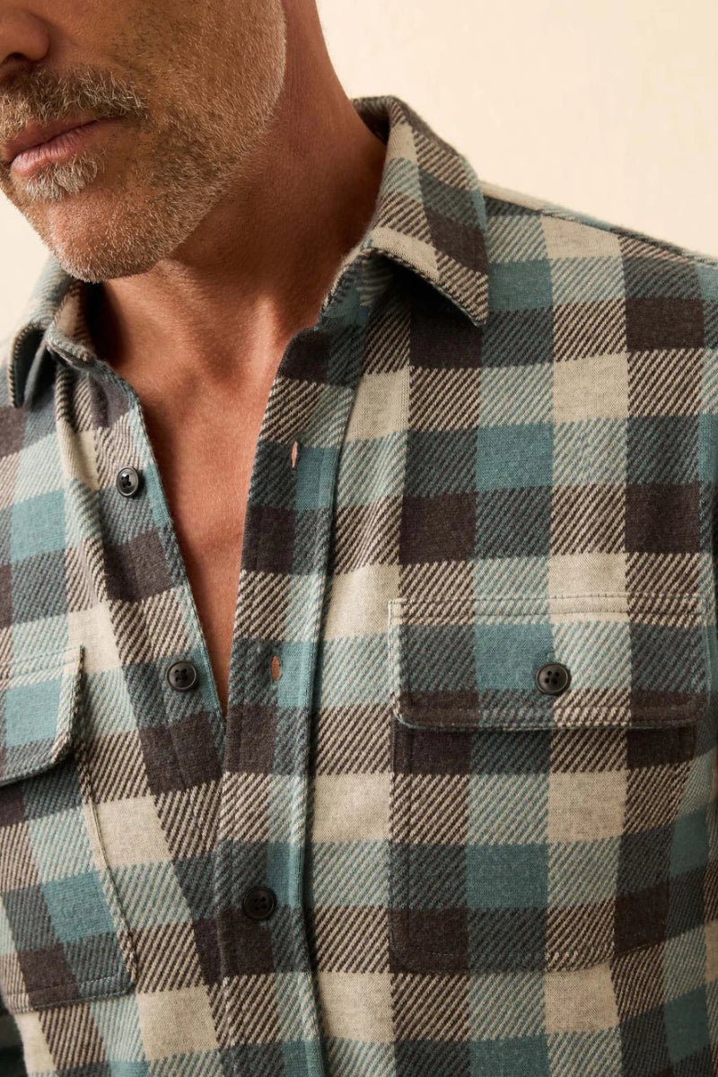 Man wearing a plaid shirt with a neutral background