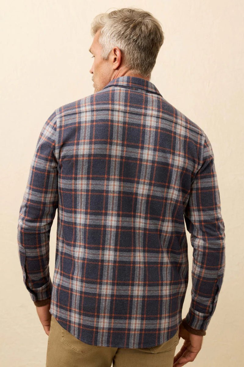 Man wearing a plaid shirt against a beige background