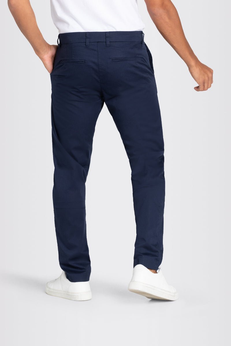 Navy pants worn by a person on a white background