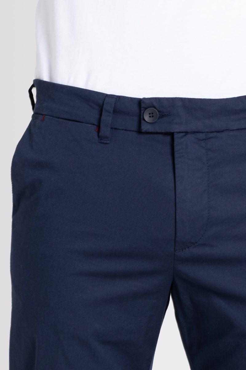 Navy blue pants with a white shirt on a light gray background