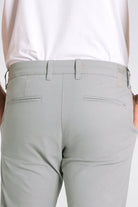 Light gray pants worn by a person on a white background