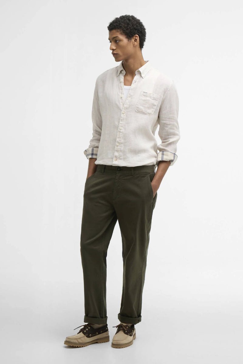 Person wearing a white shirt and green pants on a white background