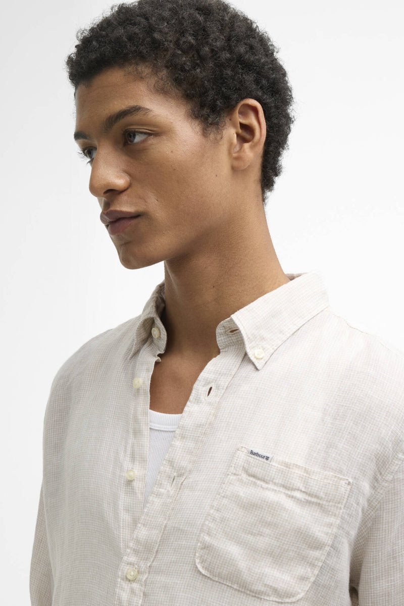 Person wearing a light-colored shirt against a plain background