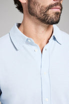Light blue textured shirt worn by a person with a neutral background