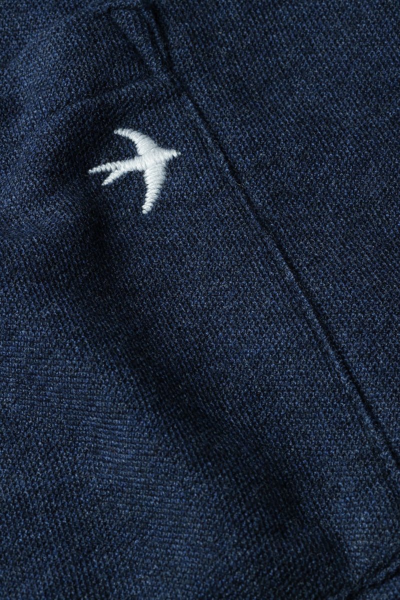 Navy blue fabric with a white embroidered bird design