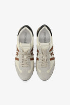 Pair of white sneakers with brown accents on a white background
