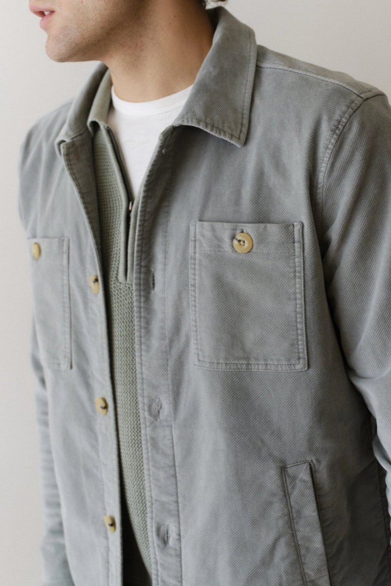 Gray jacket worn by a person on a plain background