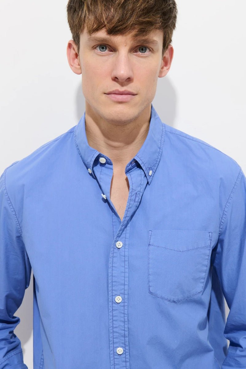 Man wearing a blue shirt against a white background