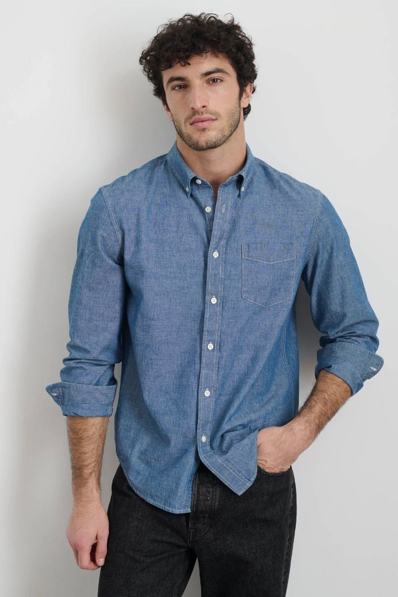 Man wearing a blue button-up shirt against a plain background