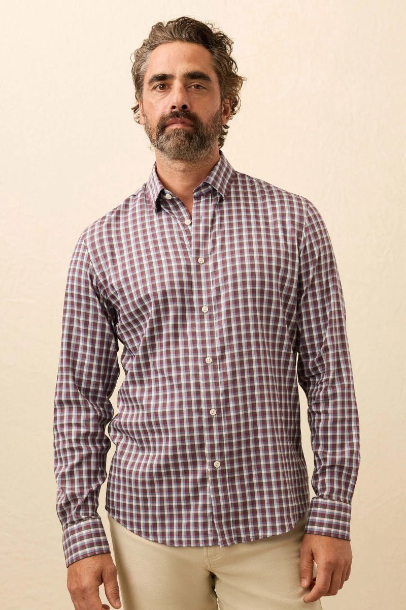 Man wearing a purple checkered shirt against a beige background