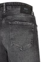 Close-up of a pair of gray jeans with a visible MAC label on a white background