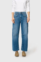 Person wearing blue jeans and a white sweater on a white background