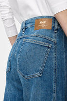 Blue jeans with a visible brand label on a white background