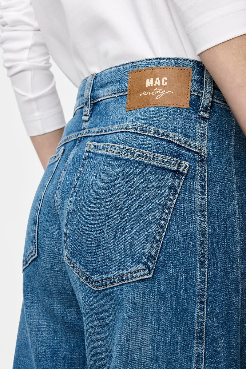 Blue jeans with a visible brand label on a white background