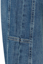 Close-up of blue denim fabric with stitching details