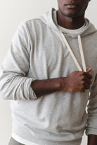 Person wearing a gray hoodie against a plain background