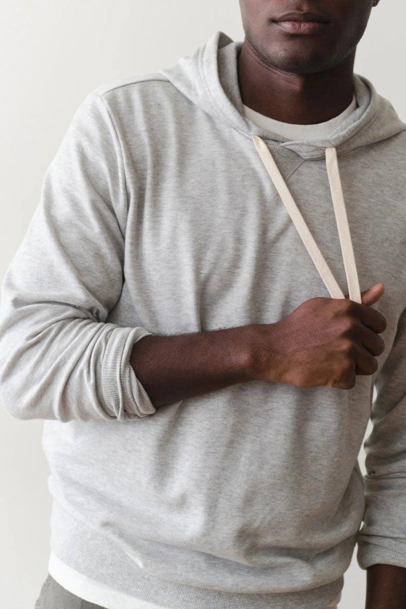Person wearing a gray hoodie against a plain background