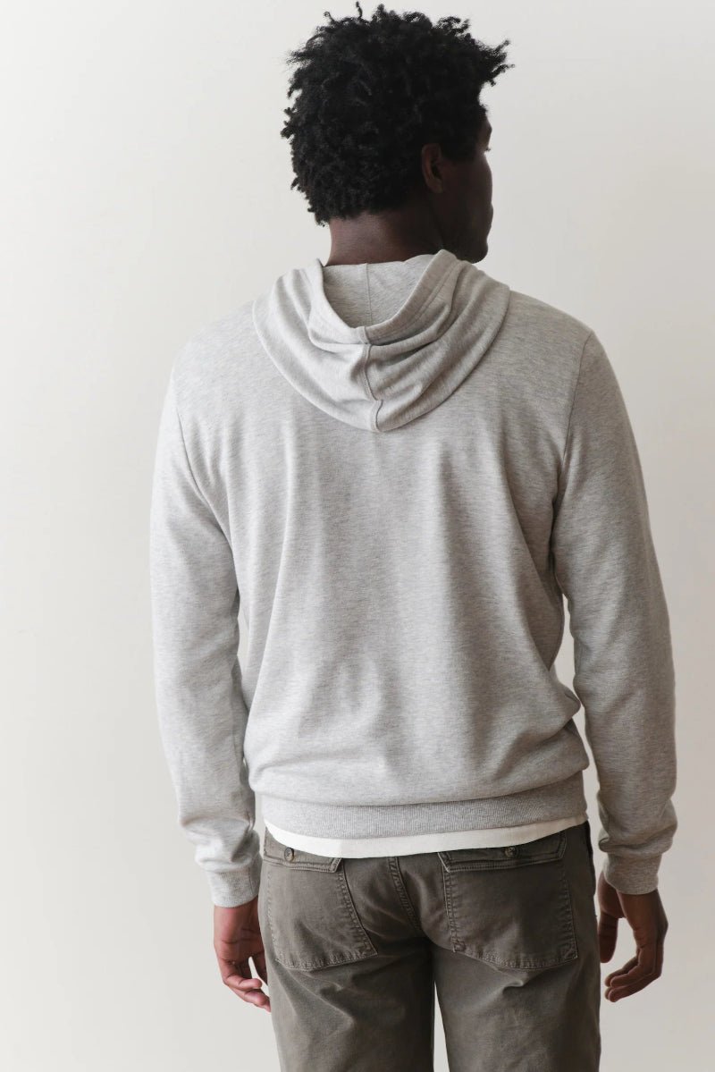 Person wearing a gray hoodie from behind on a plain background