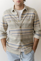 Man wearing a striped shirt with a plain background