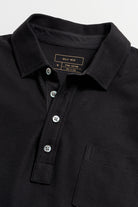 Close-up of a black polo shirt with brand label on collar