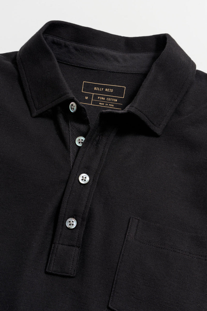 Close-up of a black polo shirt with brand label on collar